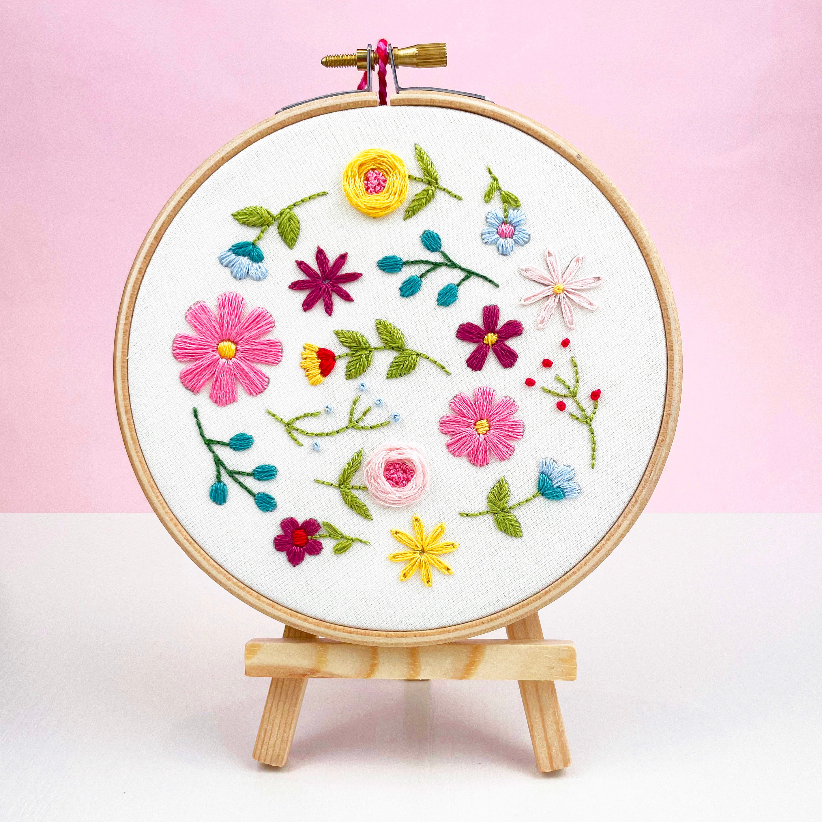 Wildflower embroidery hoop displayed against pink background – easy stitching kit for adults or gift for crafter.