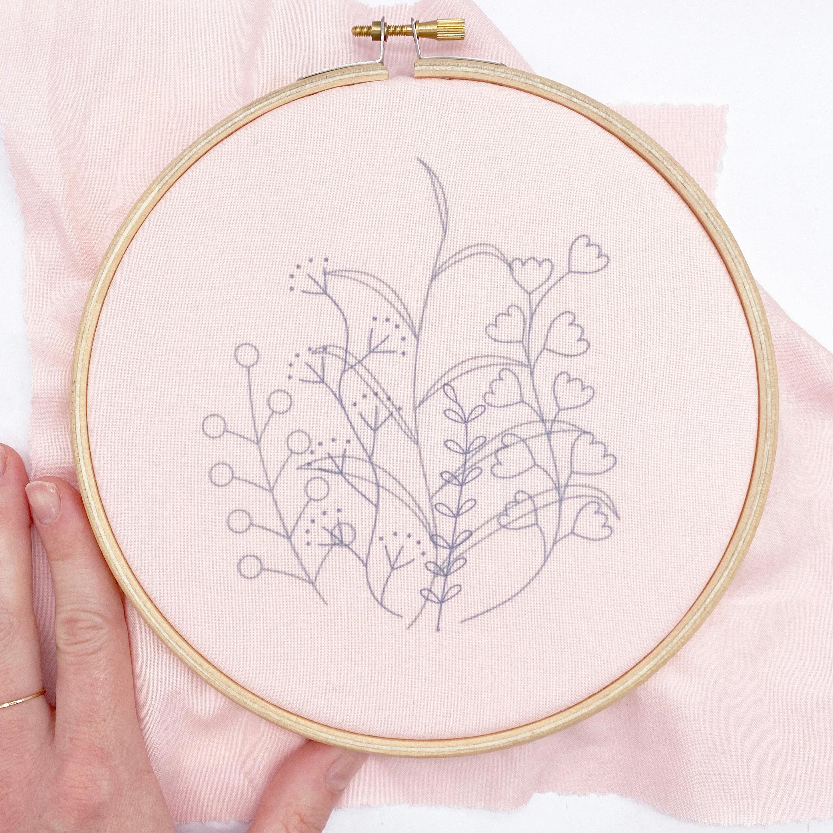 Embroidery hoop with botanical design ironed onto fabric